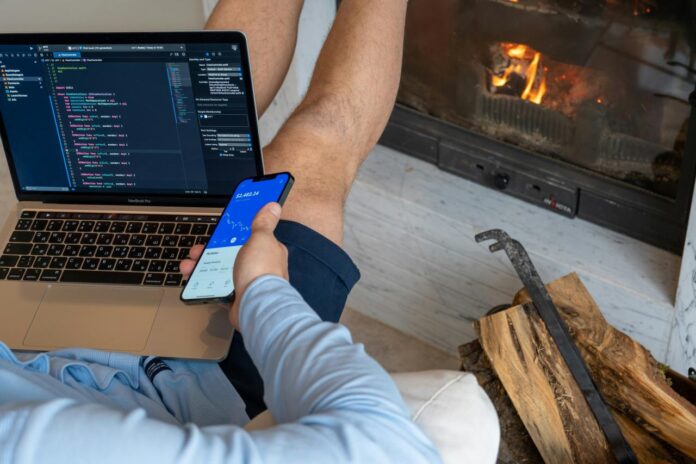 seseorang yang duduk di depan komputer laptop