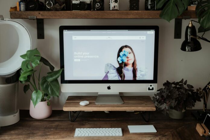 imac perak di atas meja kayu coklat