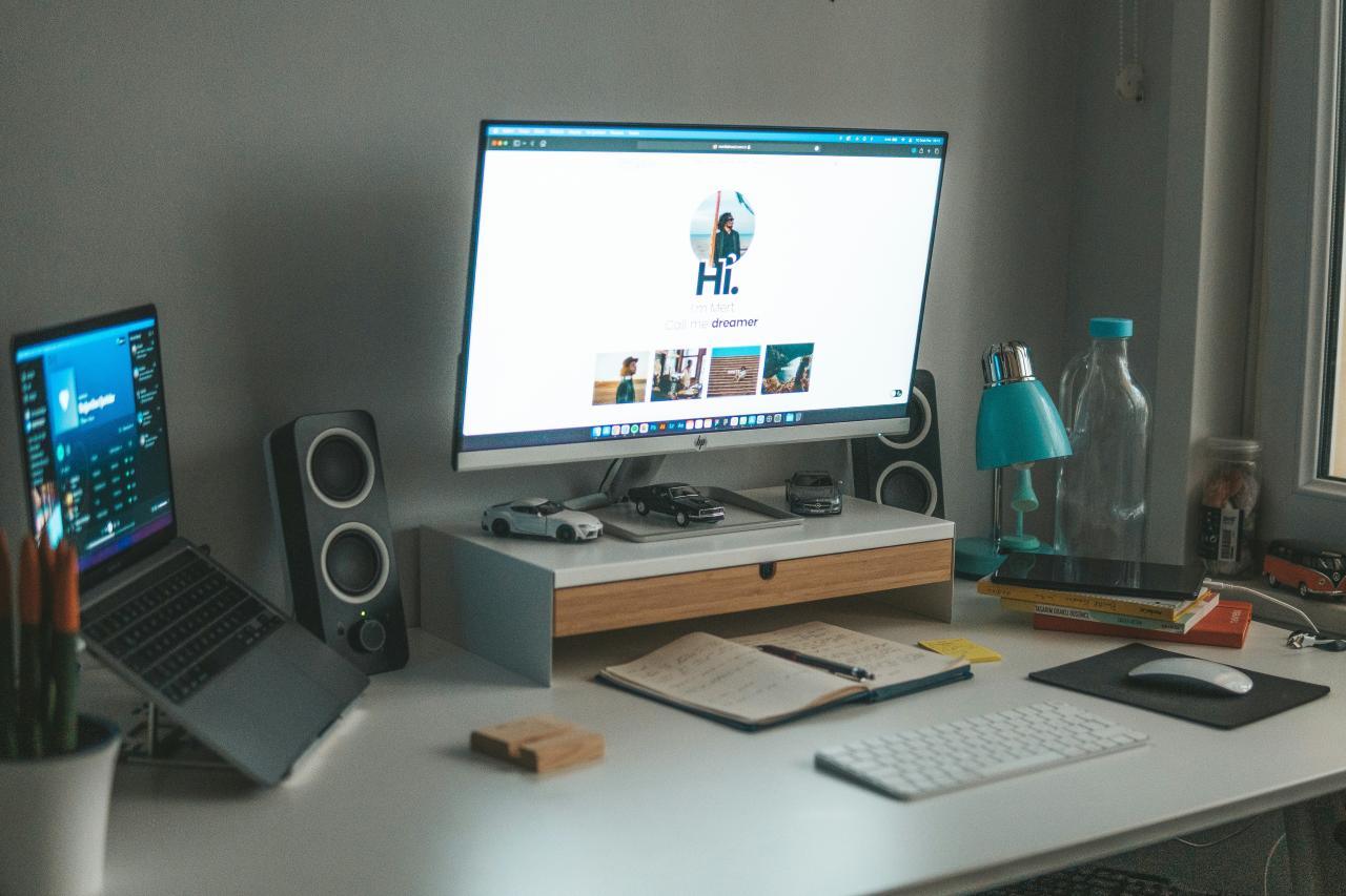 meja dengan komputer dan laptop di atasnya