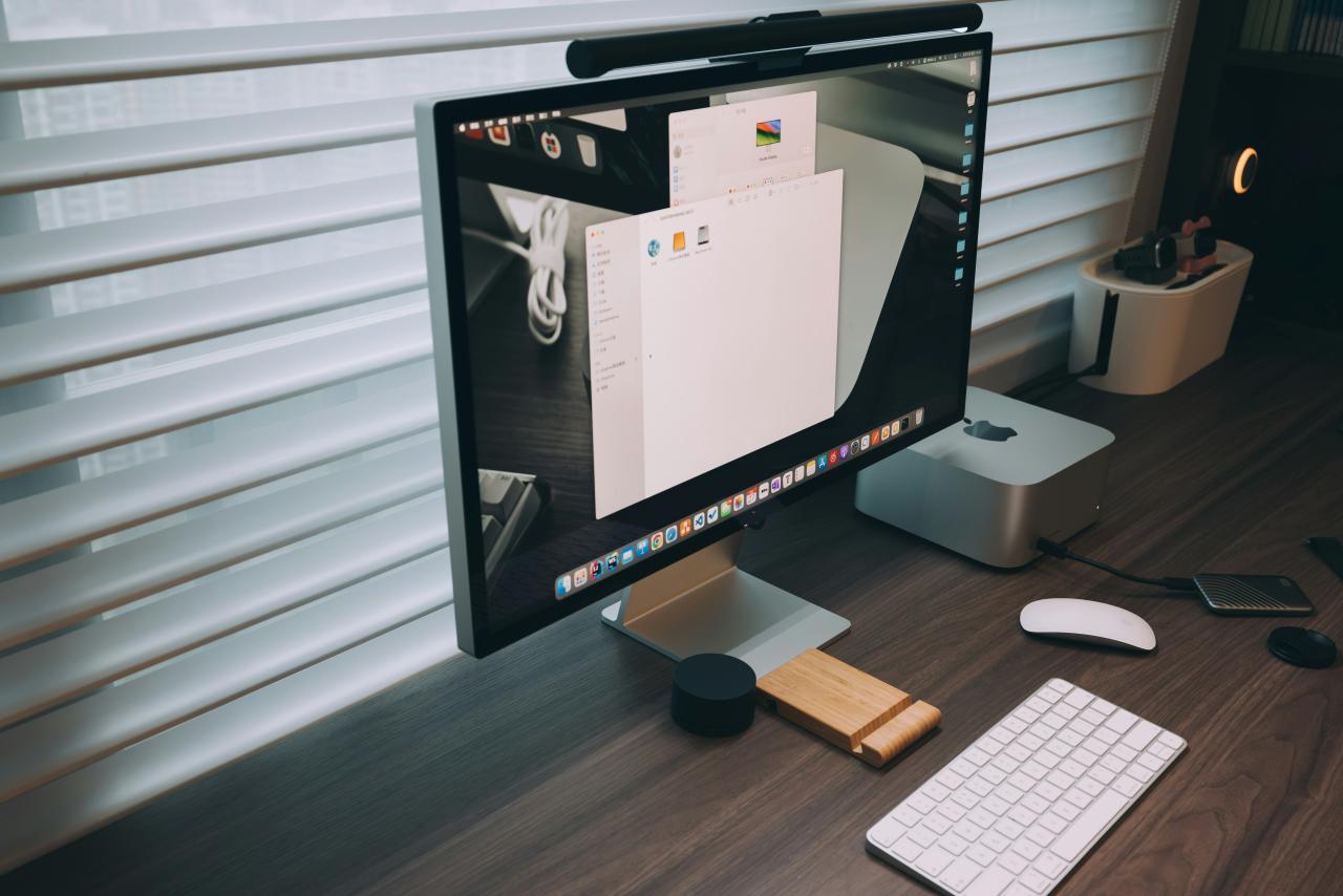 monitor komputer yang duduk di atas meja kayu